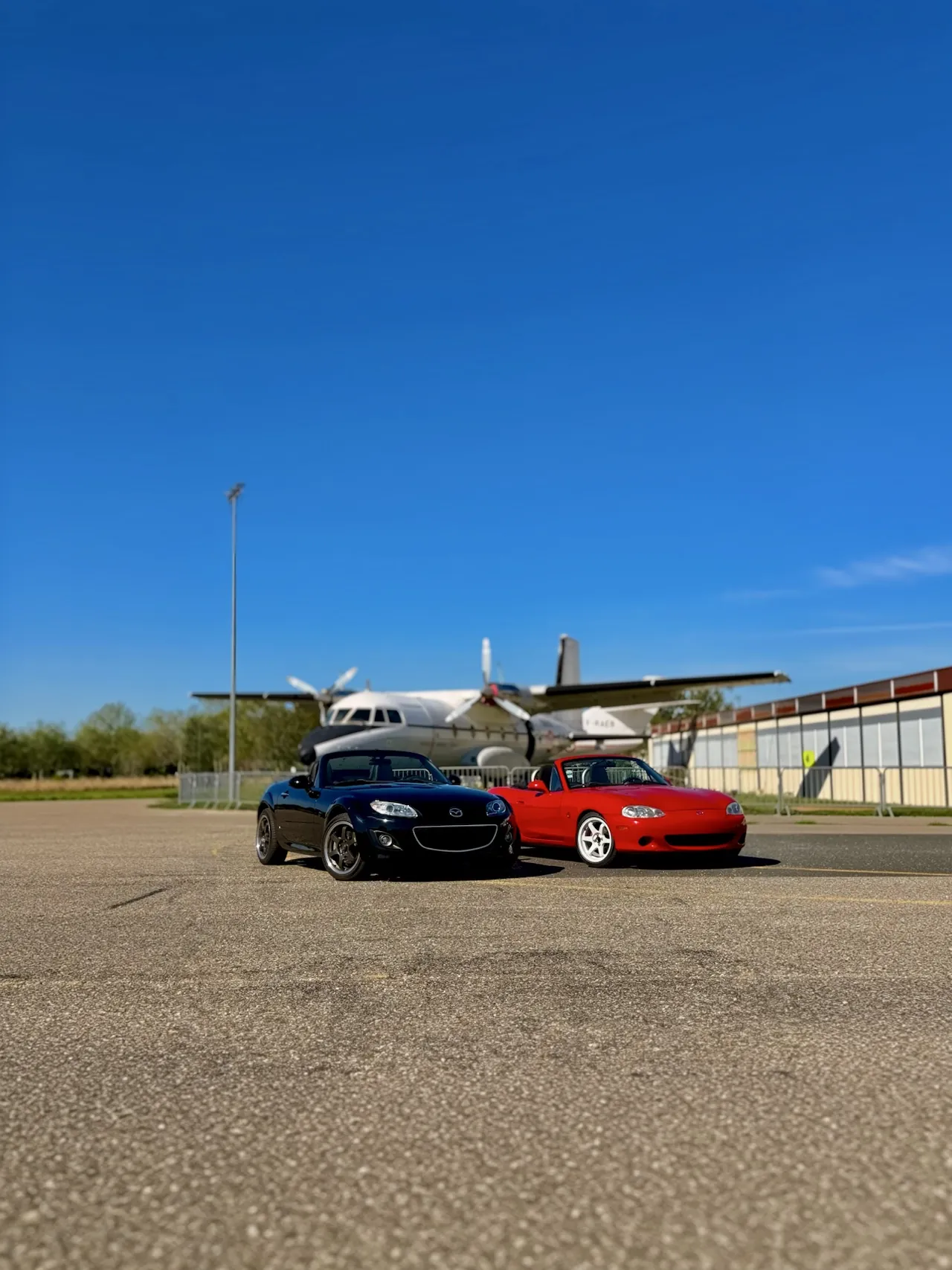 MX-5 NC et NB devant un avion à l'aérodrome de Corbas.